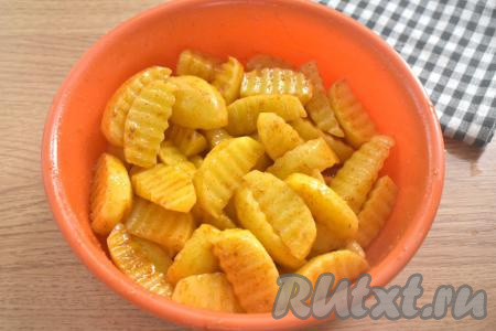 Тщательно перемешиваем дольки картофеля, покрывая их специями и маслом со всех сторон.