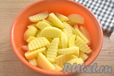 Картофель нарезаем на средние дольки (я нарезала фигурным ножом, можно нарезать и обычным), кладём в глубокую миску.