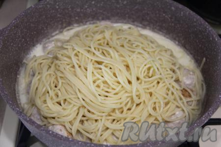 В качестве дополнения к фрикаделькам можно подать практически любой гарнир. Я сварила спагетти, для этого выложила их в кипящую подсоленную воду, перемешала и отварила в течение 7 минут, затем лишнюю воду слила. Переложила спагетти в сковороду с фрикадельками, протушившимися в сырном соусе, перемешала и прогрела на небольшом огне в течение 2 минут.