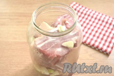 Грудинку вперемешку с чесноком выкладываем в стеклянную банку (я использовала банку объёмом 1,5 литра).