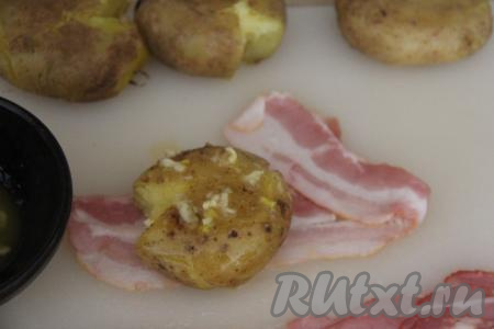 Выложить картошину на полоску бекона. Смазать картофель приготовленным пряным маслом.
