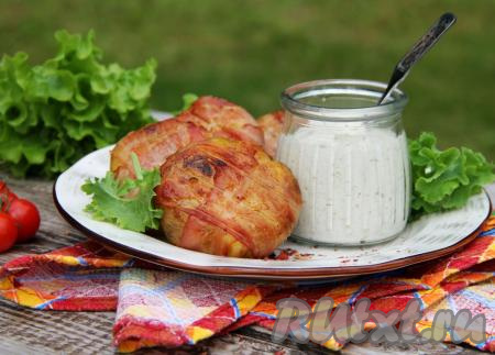 Готовую картошку в беконе снять с мангала, переложить с решётки на тарелку и подать к столу в горячем виде вместе с любимым соусом.