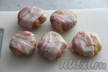 Завернуть картошину в полоску бекона. Аналогично смазать пряным маслом и завернуть в полоски бекона все картошины.