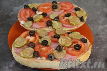 Маринованный огурец и маслины нарезать на тонкие кружочки и тоже выложить на батон.