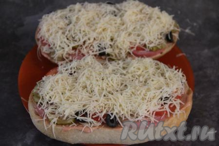 Пиццу из батона щедро посыпать сыром, натёртым на мелкой тёрке.