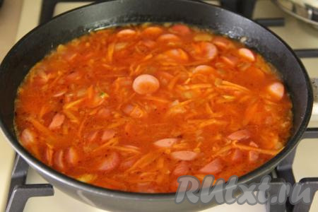 Влить в сковороду горячую воду (я влила кипящую воду из чайника), перемешать. Как только вода закипит, убавить огонь до минимума, накрыть сковороду крышкой и готовить рис с сосисками на медленном огне минут 25 (до полного испарения воды). Рис за это время полностью приготовится.