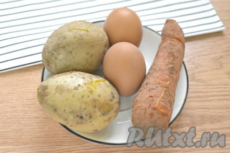 Заранее для нашего салата "Оливье" отвариваем картошку, морковь и куриные яйца. С момента закипания воды на варку картофеля в "мундире" у меня ушло 25 минут, морковка в кожуре была готова за 30 минут, а куриные яйца сварились за 10 минут. Варёные овощи и яйца остудить под ледяной водой. Все ингредиенты подготовлены, можно приступать к их нарезке.