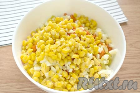 Зёрна сладкой консервированной кукурузы сначала откидываем на сито, чтобы слить лишнюю воду, а затем тоже добавляем в миску.