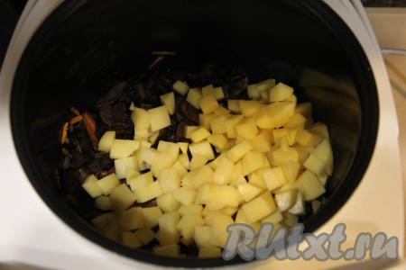 Когда морковка станет достаточно мягкой, выложить в чашу подготовленные грибы, перемешать и обжарить с овощами в течение 5 минут, периодически их перемешивая. Крышку мультиварки закрывать не нужно. Затем добавить картошку, нарезанную на средние кубики.