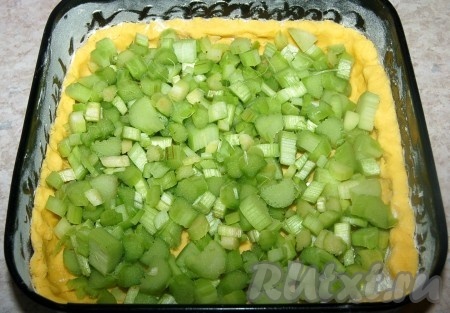 Выложить на тесто кусочки ревеня и отправить пирог в заранее нагретую до 180 градусов духовку и выпекать 30 минут почти до готовности.
