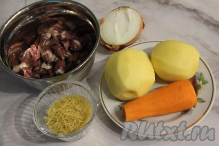 Подготовить продукты для приготовления супа с куриными сердечками и вермишелью. Почистить картошку, морковь и лук. Картофель до тех пор, пока не придёт время добавить его в кастрюлю, полностью залить водой (если не залить очищенную картошку водой, она почернеет). Куриные сердечки разрезать пополам, удалить остатки сосудов и сгустки крови, хорошо промыть водой. 
