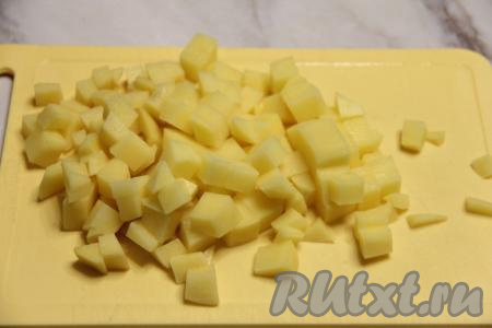 По прошествии 30 минут с момента закипания бульона с сердечками, нарезать картошку на средние кубики.