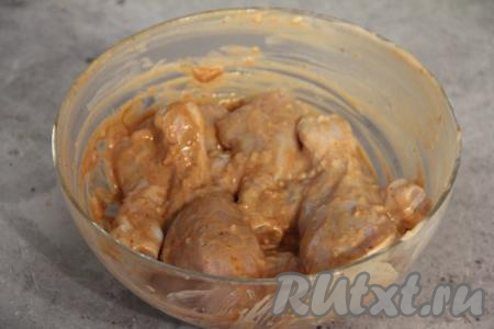 Перемешать куриные ножки, покрывая их солью, чесноком, сметаной, кетчупом со всех сторон, и оставить промариноваться минут на 30.