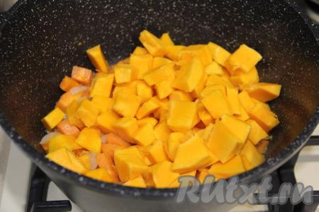 500 грамм тыквы, предварительно очищенной от семечек с волокнами и от кожуры, нарезать на средние кубики, добавить в кастрюлю, перемешать и обжаривать овощи минут 7. Во время жарки периодически не забываем перемешивать овощи, чтобы они не подгорели.
