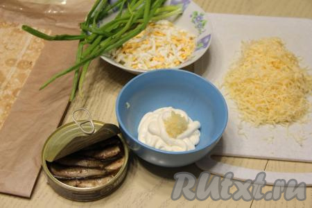 В небольшую ёмкость выложить майонез, добавить к нему пропущенные через пресс зубчики чеснока, перемешать. Сыр и яйца натереть на крупной тёрке.