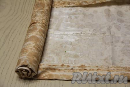 Подвернуть края лаваша с двух сторон, как на фото. Свернуть лаваш с начинкой в плотный рулет, начиная с края с начинкой.