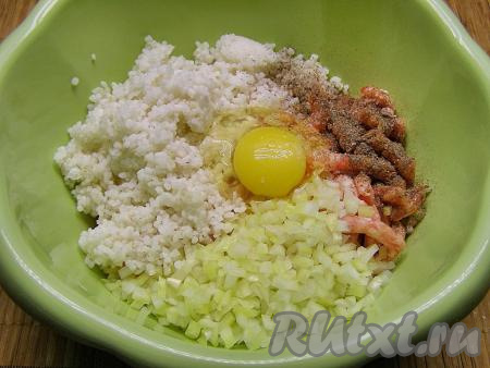 Фарш для приготовления голубцов можно приготовить в домашних условиях, пропустив через мясорубку кусочки мяса (я сделала фарш из свинины и говядины), а можно взять покупной. Выкладываем в объёмную миску получившийся фарш, добавляем остывший рис, нарезанный лук, яйцо, солим и перчим по вкусу, перемешиваем до однородности.