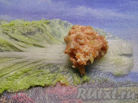 На толстый край остывшего листа кладём примерно 1 столовую ложку фарша.