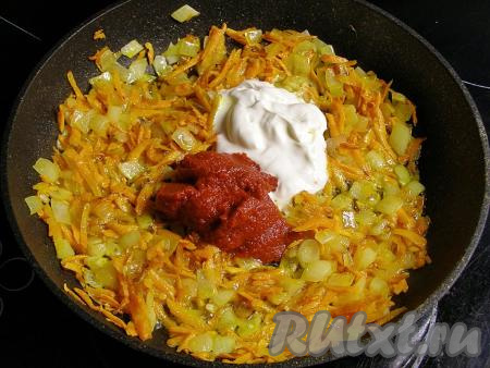 Прогреваем в сковороде растительное масло, выкладываем морковку с луком и обжариваем овощи на среднем огне минут 5 (до мягкости), периодически помешивая. Затем добавляем томатную пасту, сметану и ещё раз хорошо перемешиваем.