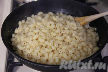 Сварившиеся макароны откинуть на дуршлаг, чтобы убрать лишнюю воду, промывать водой их не нужно. После того как фарш с яйцами обжарится до готовности, добавить в сковороду макароны.