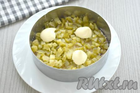Нарезаем маринованный (или солёный) огурец на небольшие кубики, выкладываем равномерно поверх лука, тоже смазываем майонезом.