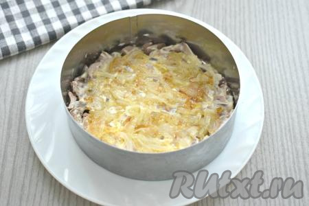 Далее на печень выкладываем обжаренный лук, равномерно распределяя его по двум кольцам.