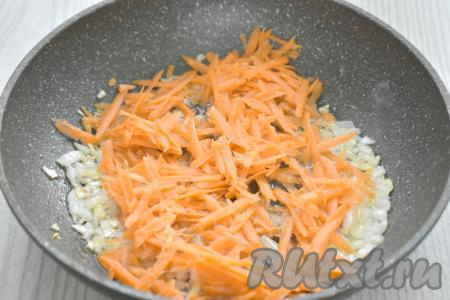 К обжаренному луку выкладываем очищенную морковку, натёртую на крупной тёрке, перемешиваем, и обжариваем овощи 4-5 минут (морковка должна стать мягкой), время от времени помешивая.