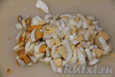 Пока гречка варится, нарезать очищенные яйца на мелкие кубики.