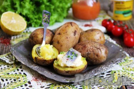 Картофель подать к столу в горячем виде. Картошечка получается хорошо пропечённой внутри. Я разрезала картошку пополам, смазала плавленным сыром и подала к столу с селёдочкой. Блюдо получилось и простым, и вкусным, и сытным.