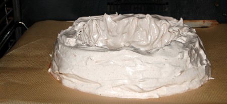 Разогреть духовку до 110 градусов и отправить туда выпекаться торт безе. Дверцу духовки с помощью палочки или ложки можно оставить  приоткрытой.