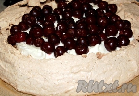 Поверх взбитых сливок выложить слой вишен без косточек.