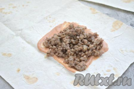 На смазанную часть лаваша выкладываем примерно 2 столовых ложки обжаренного фарша.