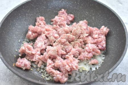 К обжаренному луку выкладываем мясной фарш, по вкусу его солим и перчим, перемешиваем.