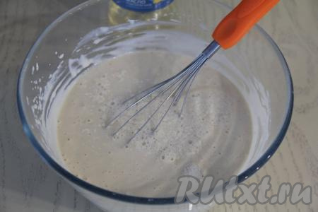 Тонкой струйкой, постоянно перемешивая венчиком, влить в блинное тесто крутой кипяток.