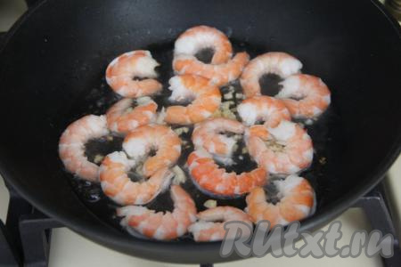 К обжаренному чесноку выложить подготовленные креветки.