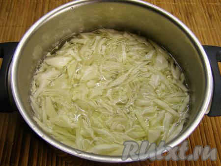 Перекладываем нарезанную капусту в кастрюлю и заливаем кипятком. Оставляем минут на 10, чтобы капуста размягчилась. Затем откидываем капусту на дуршлаг, слегка отжимаем руками, чтобы убрать лишнюю жидкость, и оставляем остывать.