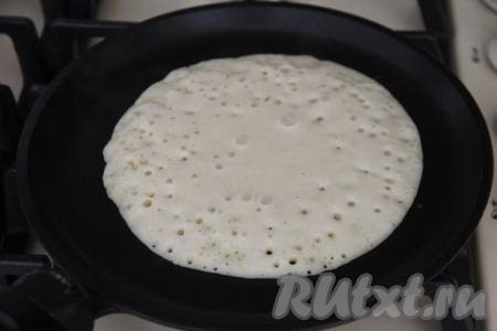 Сковороду хорошо разогреть, немного смазать растительным маслом. Влить один половник теста и распределить по поверхности сковороды. Это блинное тесто сильно не растекается, ничего страшного, если не заполнит всю поверхность сковороды. У меня получились блинчики диаметром примерно 16 сантиметров. Выпекать дрожжевой блин из пшённой каши на среднем огне до румяности снизу.