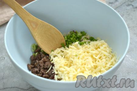 Остывший фарш с луком перекладываем в миску, добавляем сыр, натёртый на крупной тёрке. Зелёный лук (или другую зелень) моем, нарезаем мелко и добавляем в миску с фаршем и сыром. Крупное яйцо взбиваем вилкой до однородности в небольшой ёмкости. Большую часть получившейся яичной смеси вливаем в миску с фаршем и сыром. Немного взбитого яйца оставляем для смазывания пирога.