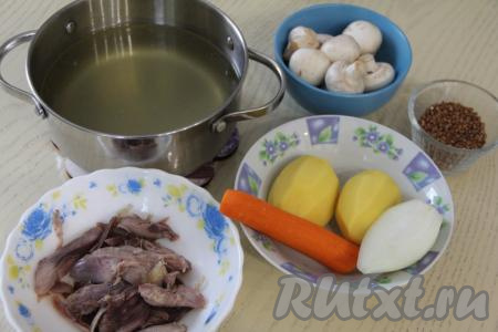 Первым делом сварим куриный бульон, для этого моем части курицы (я взяла окорочок), перекладываем в кастрюлю и заливаем 2 литрами воды, ставим на огонь. После того как бульон закипит, уменьшив огонь и тщательно убрав с поверхности пену, варим мясо минут 30-40 и убираем с огня. Сварившееся мясо достаём из бульона, даём ему немного остыть, отделяем от костей (кожу я тоже убираю). Куриный бульон, по желанию, процеживаем и возвращаем его в кастрюлю, ставим на огонь. Картошку, лук и морковь чистим. Шампиньоны промываем водой.