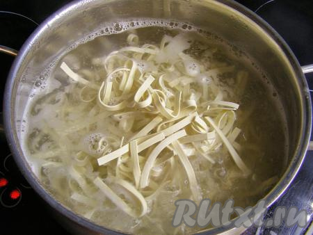 Пока мясо курицы тушится с овощами, отварим лапшу. Для этого в отдельной кастрюле доводим до кипения достаточно большое количество воды, добавляем в неё соль. В кипящую воду кладём лапшу для лагмана (вместо лапши можно использовать макароны "гнёзда"), перемешиваем, даём закипеть. А затем отвариваем на небольшом огне лапшу до готовности (ориентировочно в течение 5-7 минут, точное время варки смотрите на упаковке лапши, которую вы варите).