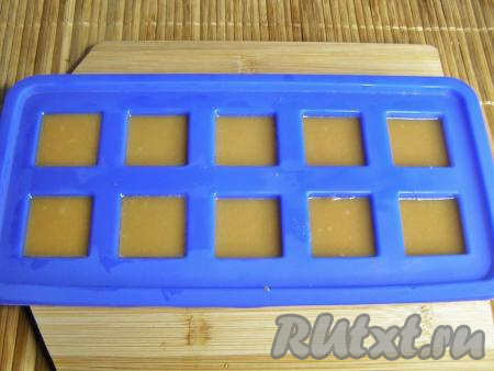 Я формировала молочные ириски в силиконовых формочках для льда, но также можно взять и пластиковые формы для льда или прямоугольный противень, застелив его пергаментной бумагой. Формочки и пергаментную бумагу (если вы используете противень) смазываем небольшим количеством сливочного или растительного масла. Разливаем горячую смесь по формочкам (или выливаем её на противень). Оставляем остыть до комнатной температуры, затем убираем в холодильник до полного застывания.