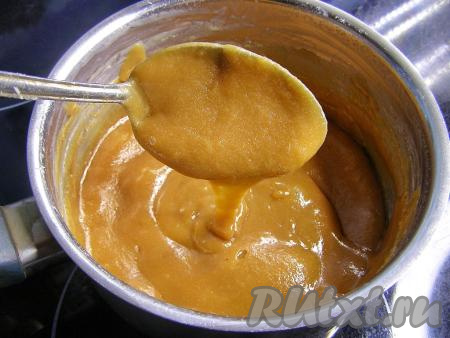 Минут через 30 масса загустеет и приобретёт карамельный цвет. Продолжаем варить на слабом огне, постоянно помешивая (чтобы смесь не пригорала ко дну сотейника), до желаемой густоты. Если сразу убрать сотейник с огня, ириски получатся мягкими, но если варить их немного дольше, они получатся более тёмными и тягучими. Проверить консистенцию можно, если капнуть несколько капель на тарелку и подождать, когда капли остынут. Если консистенция будущих молочных ирисок устраивает, выключаем огонь.