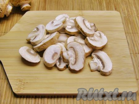 Шампиньоны ополаскиваем тёплой водой, просушиваем их на бумажном полотенце и нарезаем на пластинки толщиной примерно 5 миллиметров.