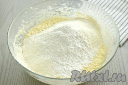 Далее в получившуюся смесь просеиваем половину муки, добавляем разрыхлитель, перемешиваем тесто для маффинов столовой ложкой.