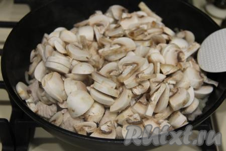 Обжаривать индейку с луком 5 минут, иногда помешивая. Шампиньоны нарезать на пластинки и добавить в сковороду к индейке и луку, перемешать.