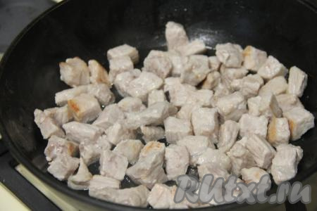 На среднем огне обжарить кусочки свинины в течение 10 минут, периодически перемешивая.