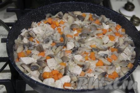 Накрыть сковороду крышкой, после закипания воды уменьшить огонь до минимума и готовить рис с курицей и шампиньонами до полного испарения воды (я с момента закипания готовила 20 минут). Рисинки должны стать мягкими, но не переваренными. Готовое блюдо убрать с огня, перемешать.