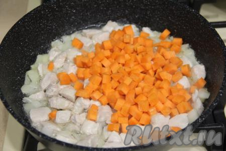 Морковь нарезать на небольшие кубики, добавить в сковороду, перемешать, обжаривать 5 минут, время от времени перемешивая.