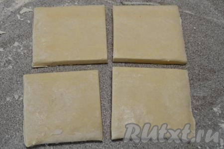 Рабочую поверхность присыпать мукой, выложить пласт размороженного слоёного теста. Разрезать тесто на 4 части.