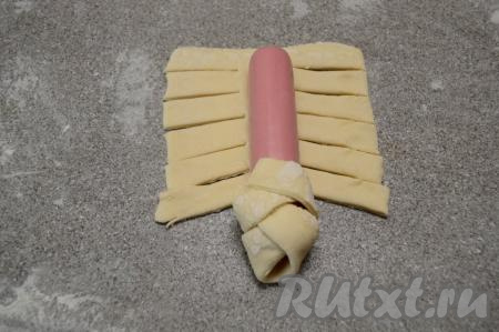 Завернуть полученные полоски теста на сосиску в виде косички, чередуя стороны.